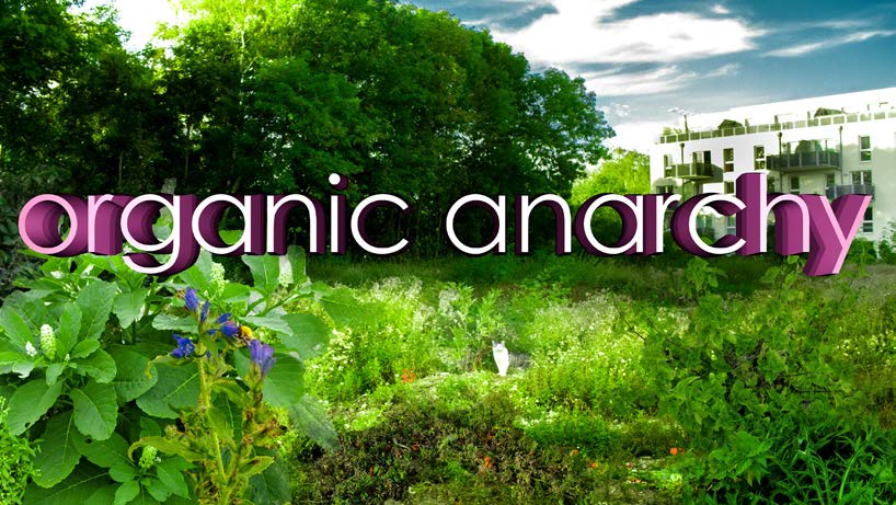 Video still: the words 'organic anarchy' in 3D letters over an overgrown green plot with a white apartment block behind. Create Your Surrounding! (2017) by Nickii Schamborski.